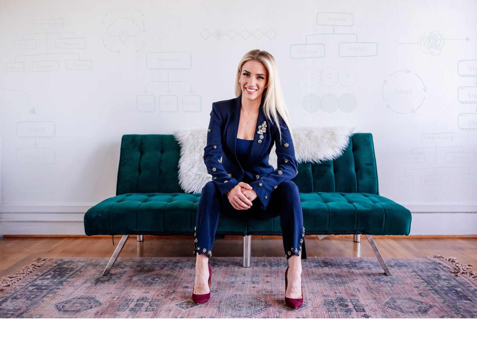 Dr. Casey Hughes in her studio, behavior-change frameworks sketched on the wall behind her